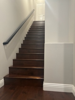 a staircase with a wooden floor and a metal hand rail